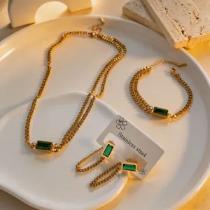 Gold-plated titanium steel jewelry set featuring emerald-cut green crystal necklace and bracelet.