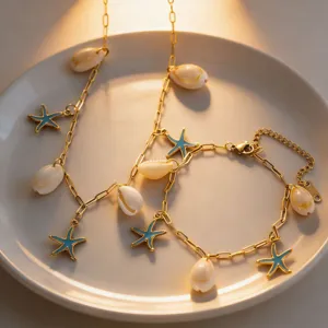 Detail shot of gold-plated seashell and blue starfish charm necklace and bracelet set.