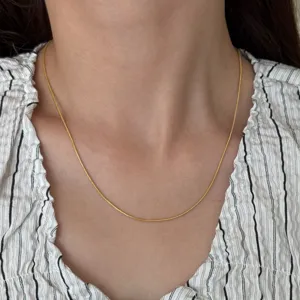 Close-up view of a delicate 18k gold plated titanium steel snake chain necklace.