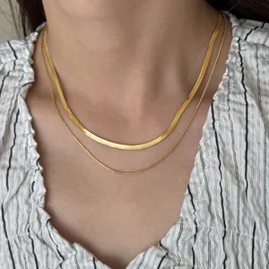 Close-up detail shot of a double layer gold plated herringbone snake chain necklace on neck.