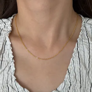Close-up detail view of the elegant 18k gold plated thin chain necklace worn on neck.
