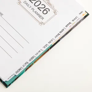 Close-up detail of 2026 daily planner notebook with monthly index tabs and lined pages.