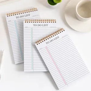 Primo piano dettagliato del taccuino planner giornaliero a spirale con lista su tavolo.