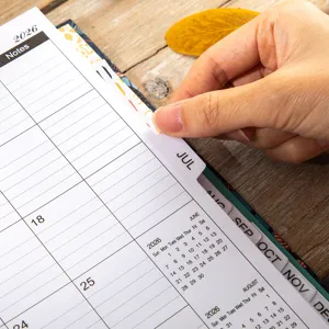 Detailed view of 2026 planner notebook with monthly tabs and calendar grid for daily schedule.