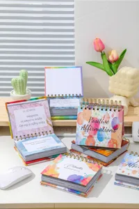 Detailed view of the 2027 English daily desk calendar with inspirational quotes and spiral bind.