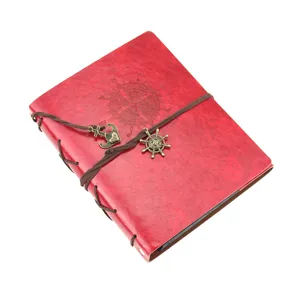 Vintage red leather photo album diary with compass embossing, rope and metal charms detail.