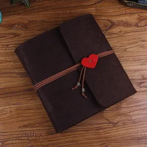 Album photo en tissu marron DIY avec bouton cœur et sangle en cuir pour souvenirs.