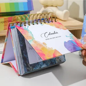 Detail view of a 2027 English motivational desk calendar with colorful spiral binding and daily pages.