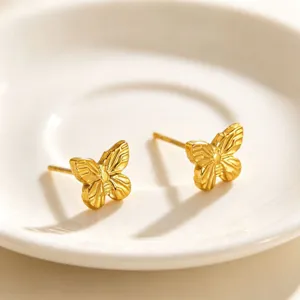 Detailed view of exquisite gold butterfly stud earrings, elegant metallic texture design.