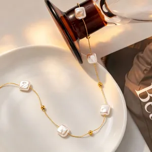 Detail view of the elegant square baroque pearl necklace with golden titanium steel chain.