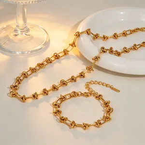 Vue détaillée du collier et bracelet en chaîne à maillons en acier inoxydable doré.