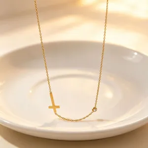 Minimalist titanium steel cross necklace with single stone detail, elegant gold jewelry piece.