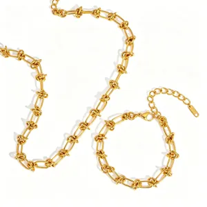 Détail de la parure de collier et de bracelet à maillons noués en acier inoxydable.