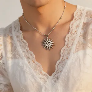 Silver sun spiral pendant necklace featuring delicate beaded chain and cutout design.
