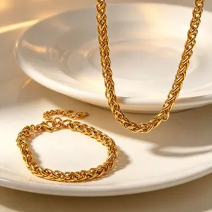 Detailed shot of gold plated stainless steel braided chain necklace and bracelet set.