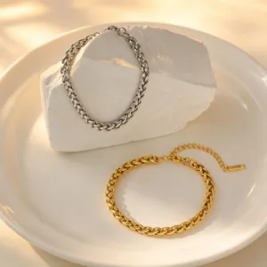 Stainless steel braided chain bracelet detail, gold and silver color fashion jewelry accessory.