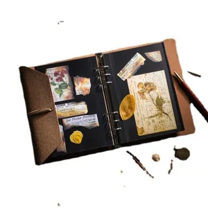 Album photo de scrapbooking DIY en cuir vintage avec pages noires et décor botanique.