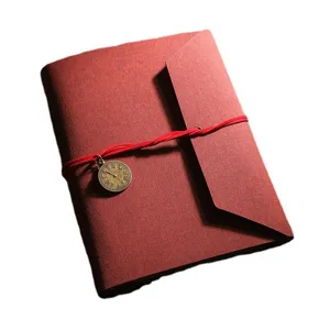 Album photo DIY rouge carnet de scrapbooking avec pendentif horloge rétro et lien rouge.