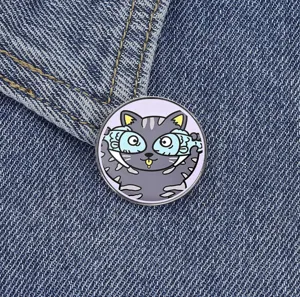 Nahaufnahme eines niedlichen Cartoon-Katzen-Emaillepins mit Fischbrillen-Design auf Denim.