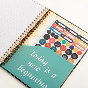 Spiral planner notebook featuring lined daily pages, inner storage pocket, and index stickers.
