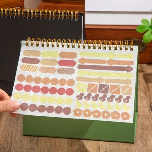 Close-up detail of Morandi color index sticky notes and desk calendar on wooden table.