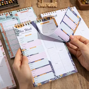 Weekly meal planner notepad with tear-off shopping list and spiral binding design.