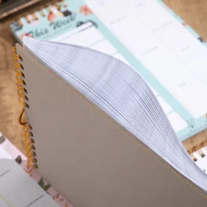 Kraft cover spiral weekly planner notebook detail view showing thick paper and binding.