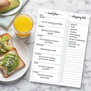 Minimalist meal planning notepad with tear-away daily recipe and shopping list for kitchen.