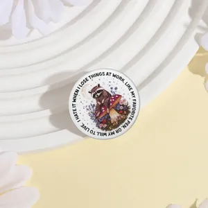 Vista dettagliata di spilla metallica procione fungo, simpatico badge con citazione.