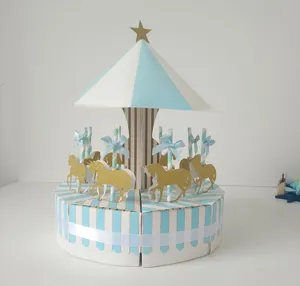 Detail view of paper carousel cake box, blue white striped candy container with gold horse decor.