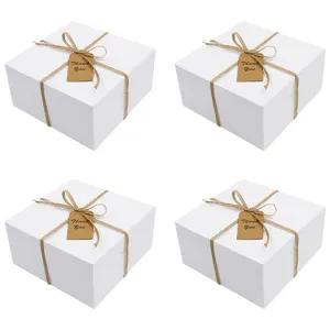 Weiße quadratische Geschenkschachteln mit Juteband und Dankeschön-Etikett für Kuchen.