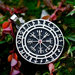 Detail shot of stainless steel Norse compass pendant with red gem and Viking runes craftsmanship.