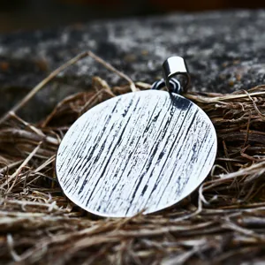 Stainless steel round pendant with textured pattern, detailed view of retro Viking style jewelry.