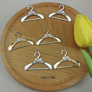 Colgante de metal con forma de percha y pedreria para hacer bisuteria y artesania.