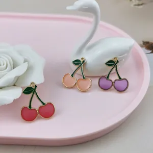 Close up of colorful cherry charms, enamel metal pendants for DIY handmade jewelry making.