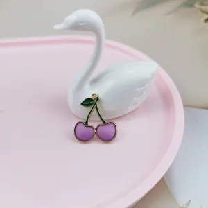 Detailed view of a cute purple cherry charm pendant with green leaf for DIY jewelry making.