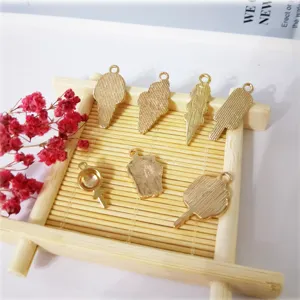 Detailweergave van schattige ijs- en lolly-legeringshangers in goud, perfect voor DIY-sieraden.