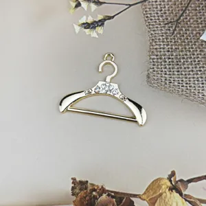 Colgante de metal dorado con forma de percha y pedrería brillante para manualidades de joyería DIY.