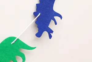 Vilt dinosaurus banner voor feestdecoratie, kleurrijke hangende slingers voor kinderverjaardag.
