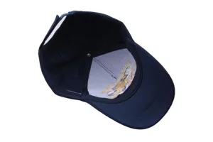 Detailed view of the inside of a navy blue commemorative baseball cap with embroidery lining.