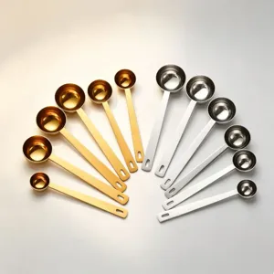 Stainless steel measuring spoon detail view, gold and silver kitchen baking tool set.