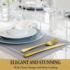 Detalle de cubiertos de acero dorado con elegante tenedor y cuchillo en mantel individual.