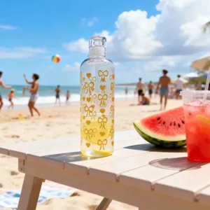 Detailaufnahme der transparenten Plastikflasche mit niedlichen gelben Schleifen am Strand.