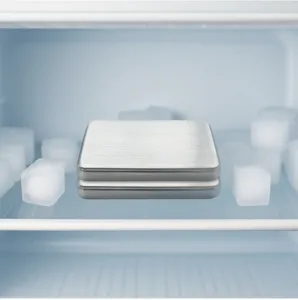 Detailed view of stainless steel ice plates placed in refrigerator with ice for cooling.