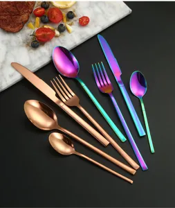 Stainless steel cutlery detail showing rose gold and rainbow knife fork spoon set on marble.