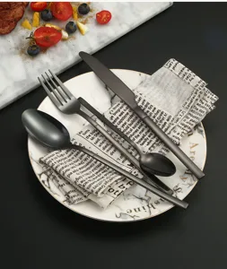 Matte black stainless steel flatware set detail, stylish cutlery set on marble plate.