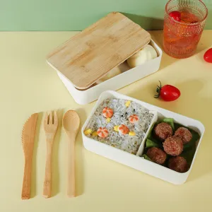 Portable double-layer bento lunch box with bamboo lid and wooden cutlery set for daily use.