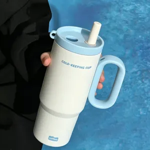 Detailed view of large stainless steel insulated tumbler with straw and handle in white and blue.