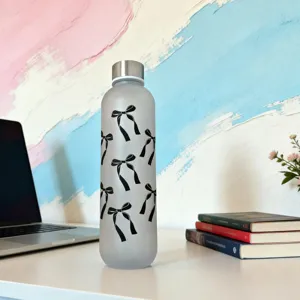 Frosted plastic water bottle detail showcasing black bow pattern design and portable metal lid.