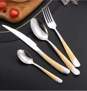 Detailed view of a stainless steel cutlery set with elegant gold textured handles for dining.